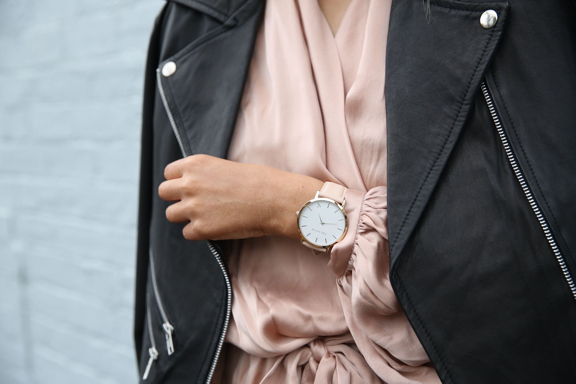 a woman with a linen shirt, a leather jacket and rose-gold watch. 