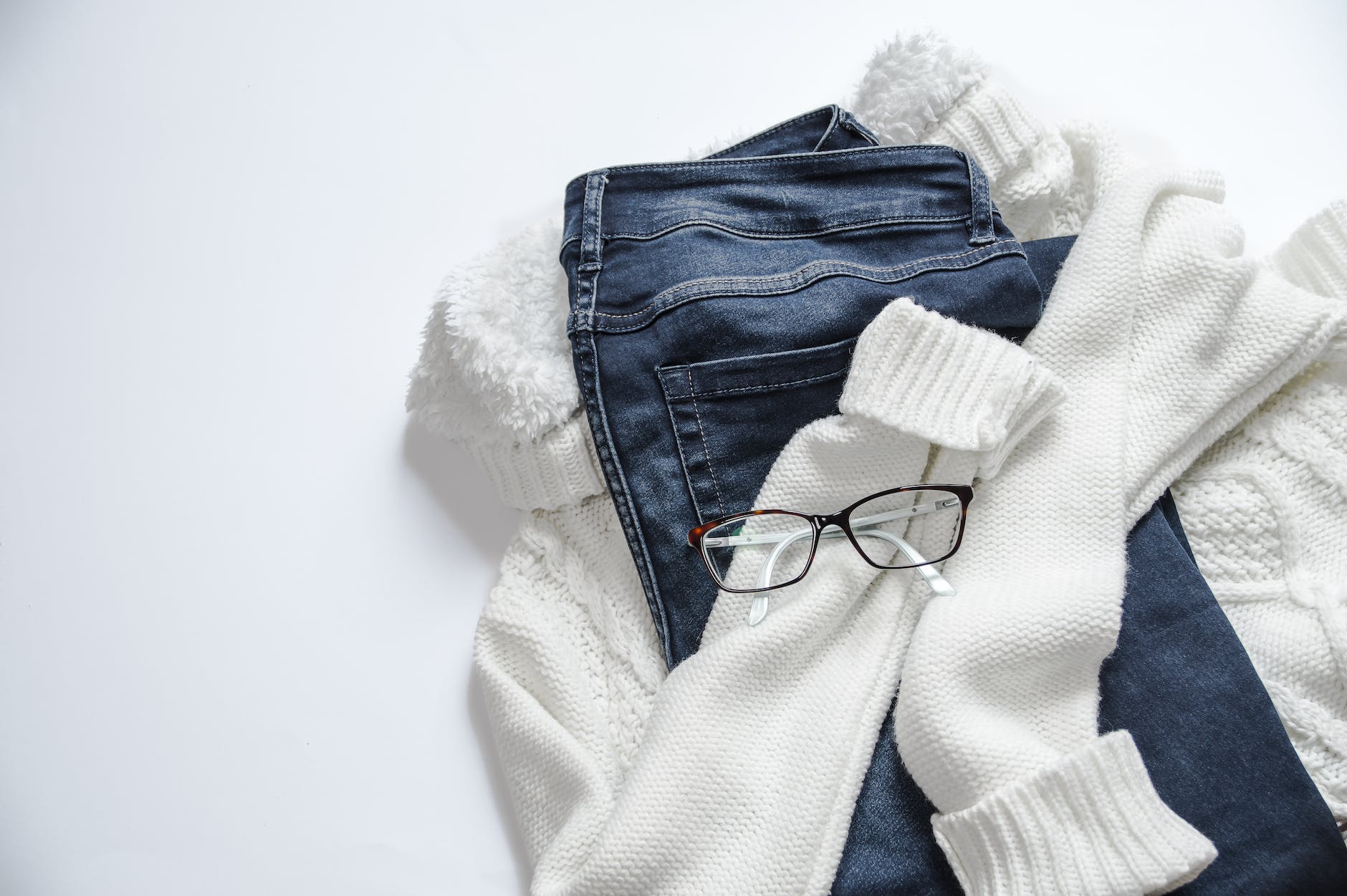 a sweater, pair of jeans, and a pair of glasses. 