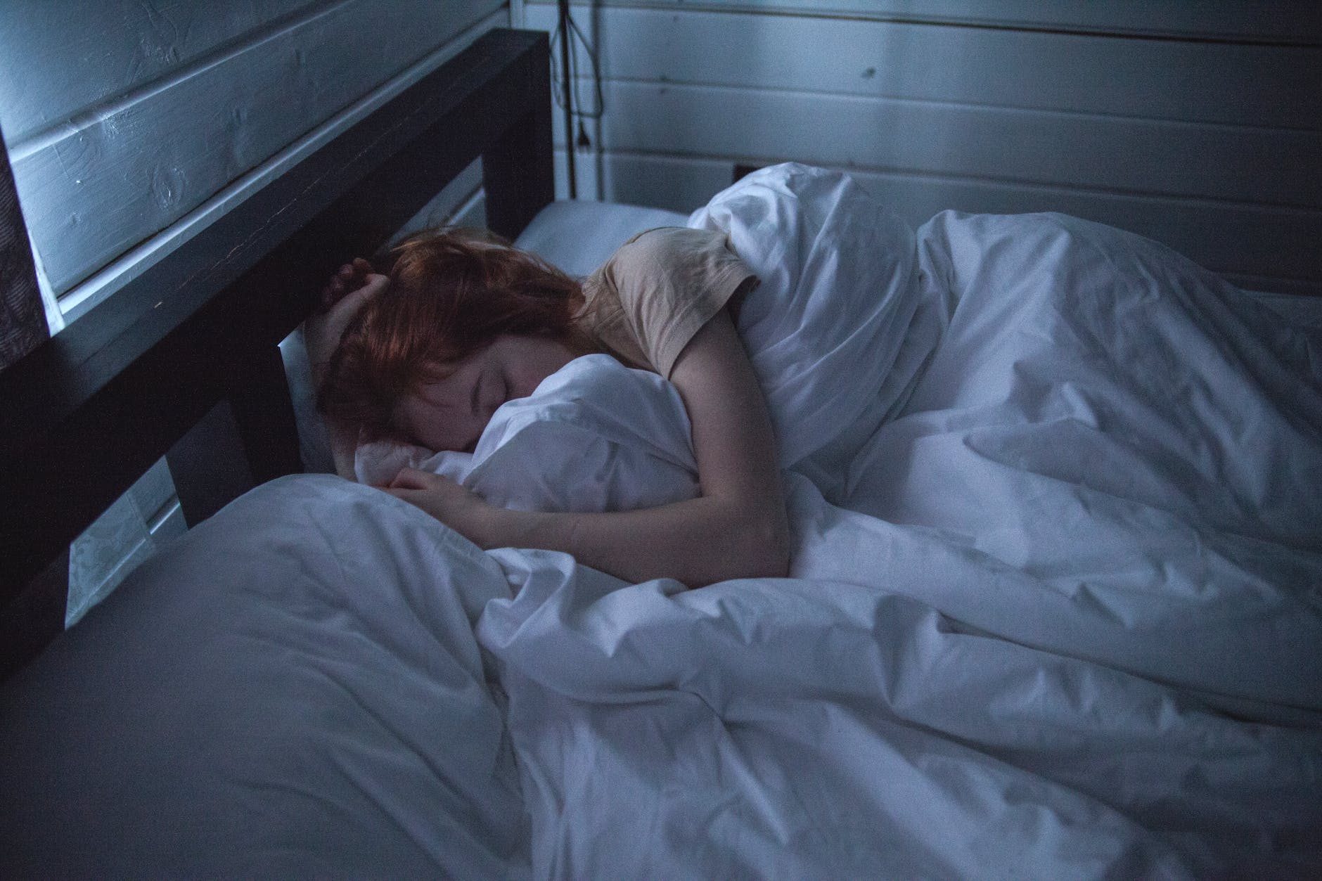 a redhaired woman sleeping in a bed 